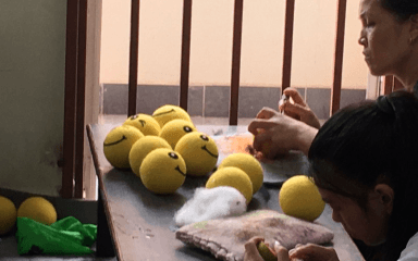 Person arranging green apples on a windowsill